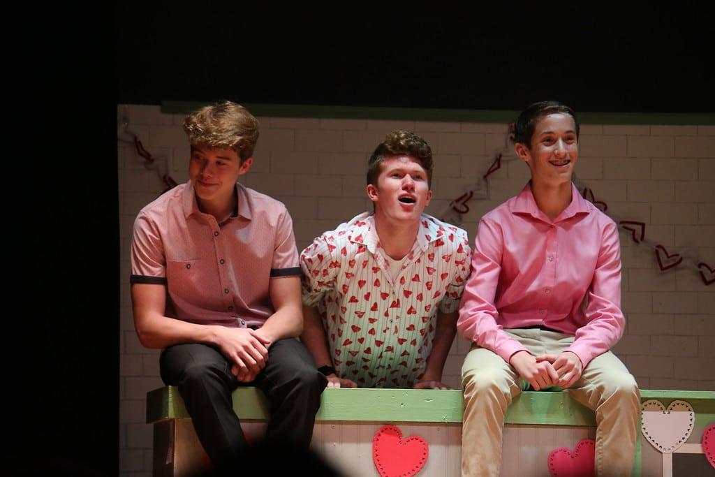 三个男学生在剧院唱歌